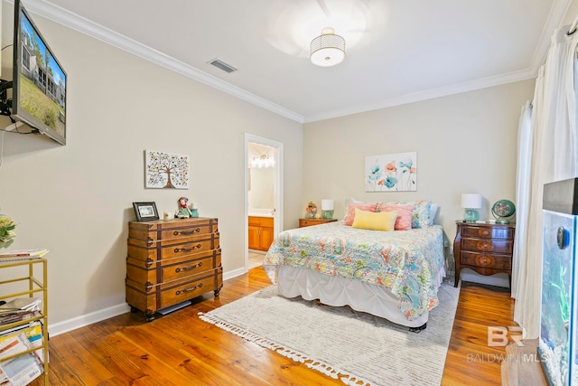 bedroom featuring ornamental molding, hardwood / wood-style floors, and ensuite bath