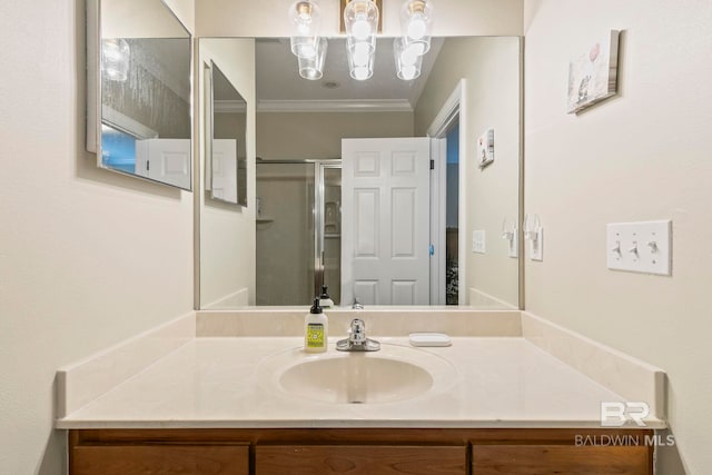 bathroom with a shower with door, vanity, and crown molding