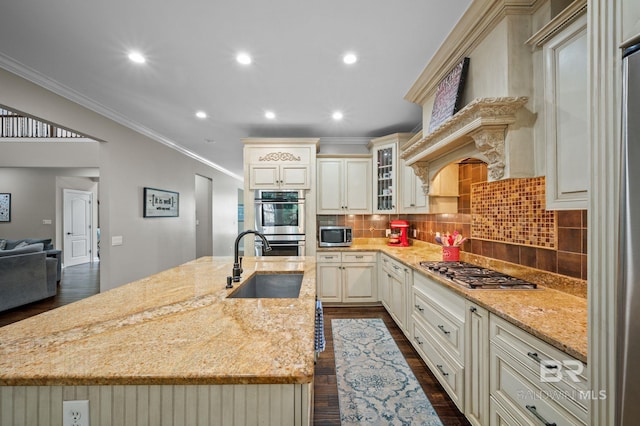 7371 Maureen Cir, Spanish Fort, AL 36527 - kitchen featuring cream cabinets, appliances with stainless steel finishes, light stone counters, crown molding, and an island with sink