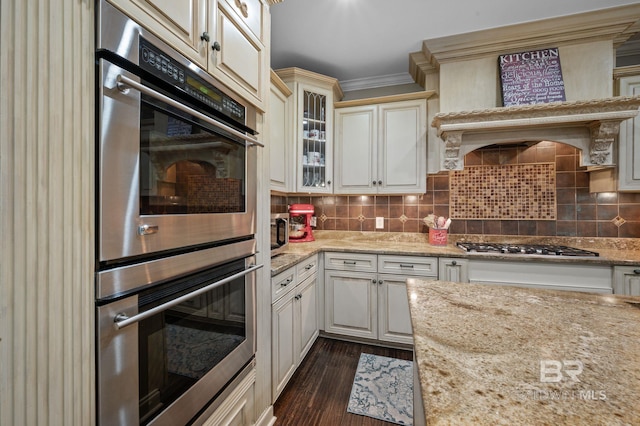 7371 Maureen Cir, Spanish Fort, AL 36527 - kitchen with stainless steel appliances, dark wood-style flooring, glass insert cabinets, light stone counters, and backsplash