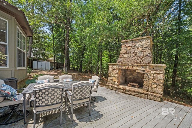 7371 Maureen Cir, Spanish Fort, AL 36527 - wooden terrace featuring an outdoor stone fireplace, outdoor dining space, and a shed