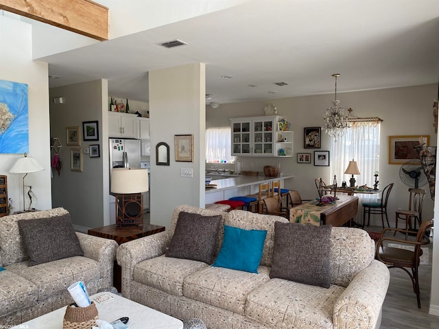 living room with dark hardwood / wood-style flooring and ceiling fan with notable chandelier