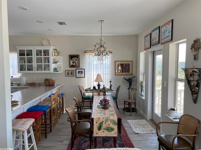 dining area with dark hardwood / wood-style floors, a notable chandelier, and a wealth of natural light