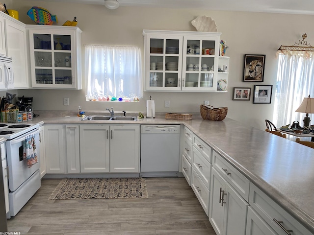 kitchen with white appliances, white cabinets, sink, and light wood-type flooring