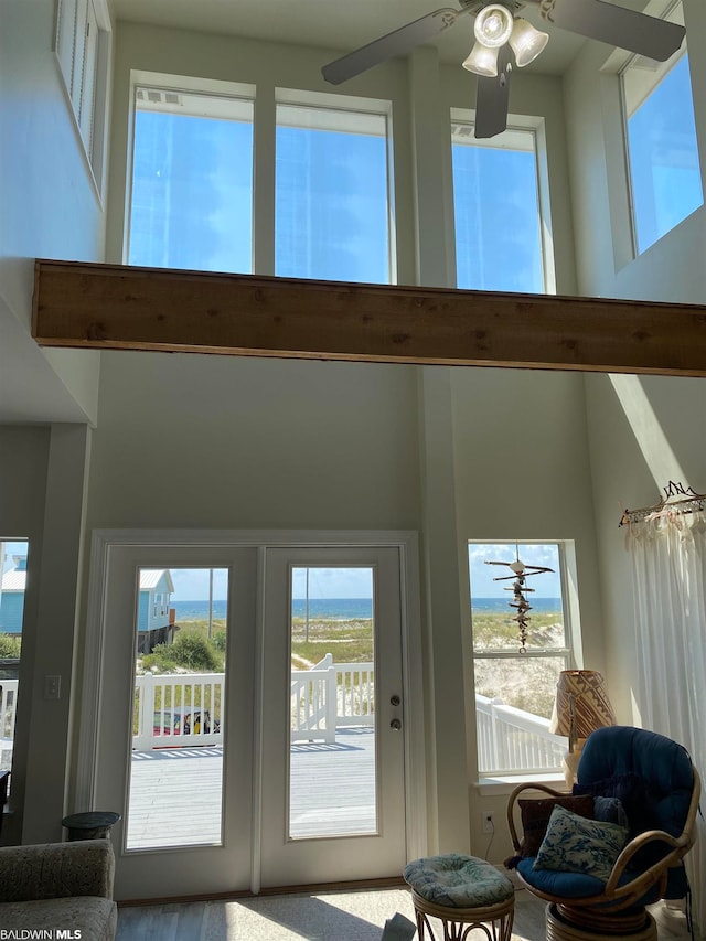 entryway with ceiling fan and a towering ceiling