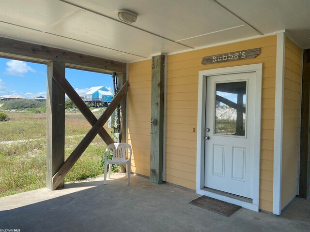 view of exterior entry with a patio area