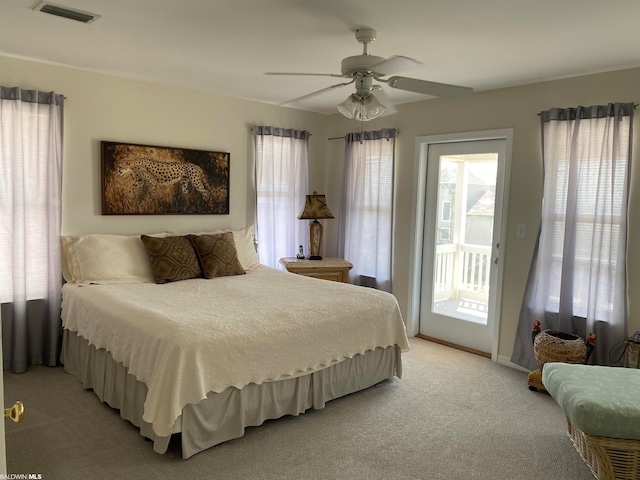 carpeted bedroom featuring ceiling fan, multiple windows, and access to outside