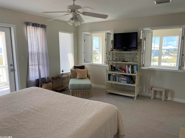 carpeted bedroom with multiple windows, access to exterior, and ceiling fan