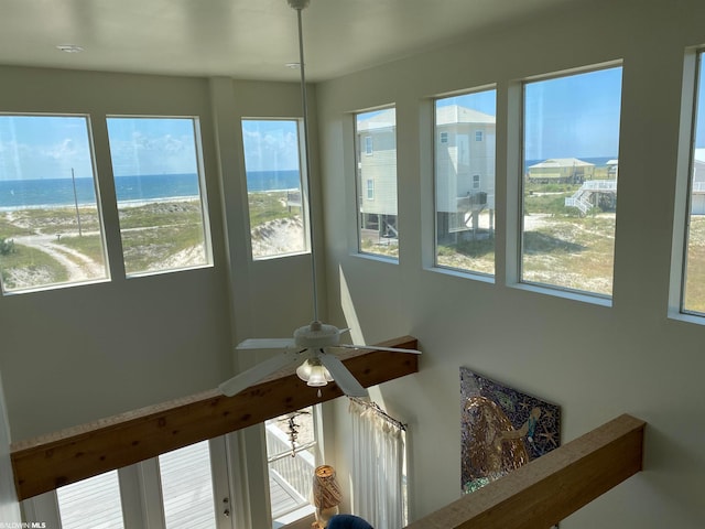 interior space with ceiling fan and a water view
