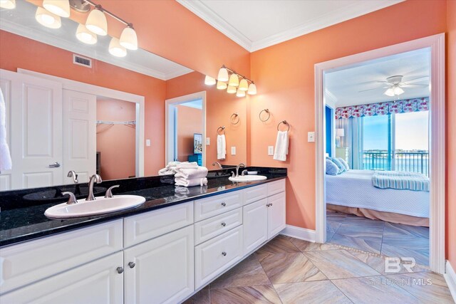 bathroom with dual sinks, oversized vanity, ceiling fan, ornamental molding, and tile floors