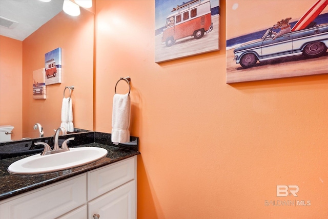 bathroom featuring toilet and vanity