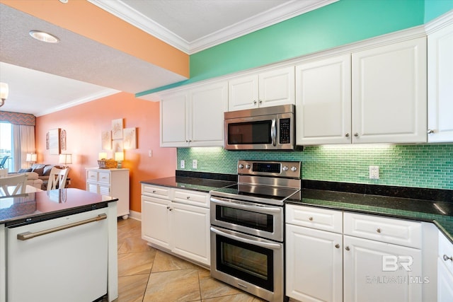 kitchen with white cabinetry, backsplash, appliances with stainless steel finishes, dark stone countertops, and crown molding