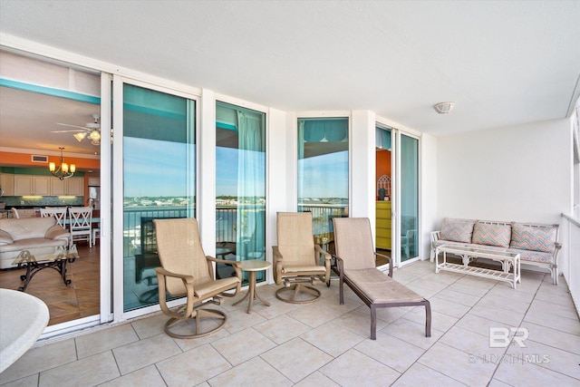 exterior space featuring light tile flooring and ceiling fan with notable chandelier