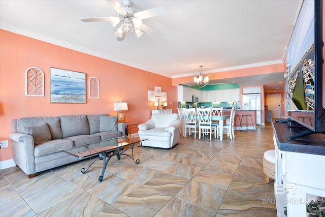 living room featuring light tile flooring, sink, ornamental molding, and ceiling fan with notable chandelier