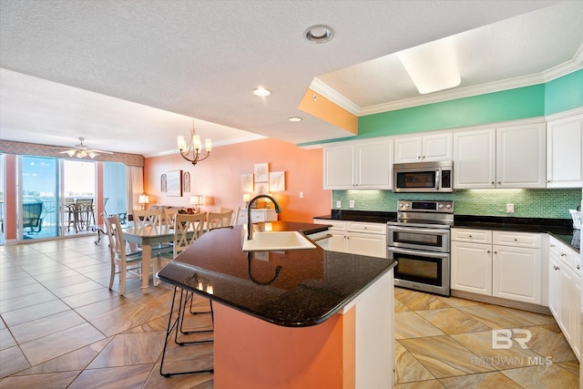 kitchen with white cabinetry, a kitchen island with sink, appliances with stainless steel finishes, and sink