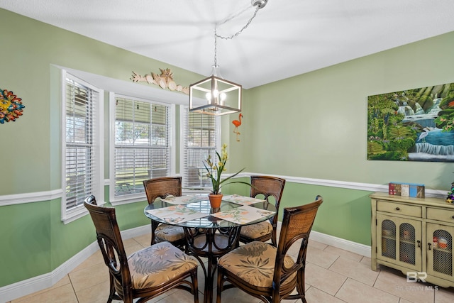 dining space featuring a notable chandelier, baseboards, and light tile patterned floors