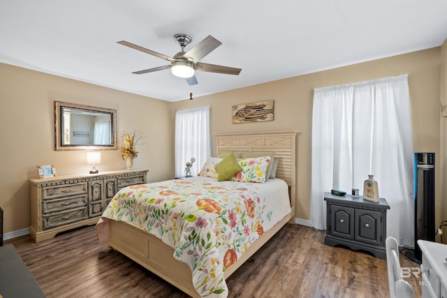 bedroom with a ceiling fan, baseboards, and wood finished floors