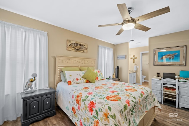 bedroom with ceiling fan, ensuite bath, and wood finished floors