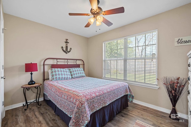 bedroom featuring a ceiling fan, baseboards, and wood finished floors