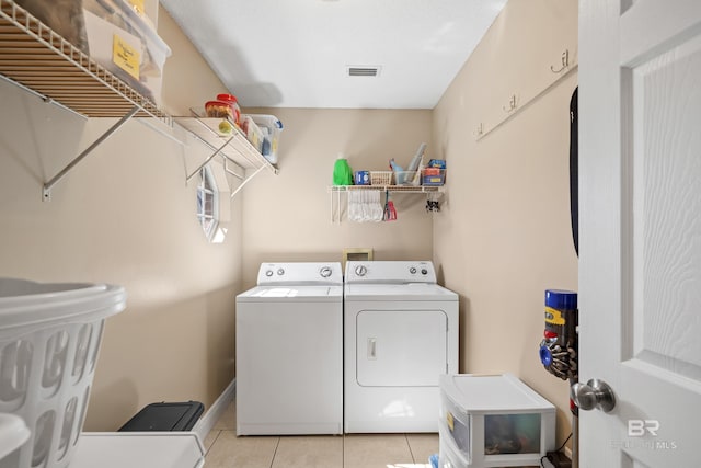 laundry room featuring laundry area, light tile patterned flooring, visible vents, and independent washer and dryer