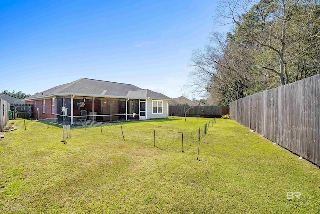 view of yard featuring a sunroom and a fenced backyard