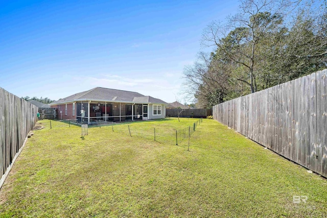 view of yard featuring a sunroom and a fenced backyard