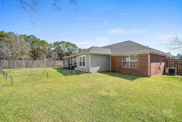 exterior space with a yard, a fenced backyard, cooling unit, and brick siding