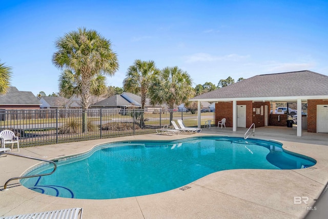 pool featuring fence and a patio