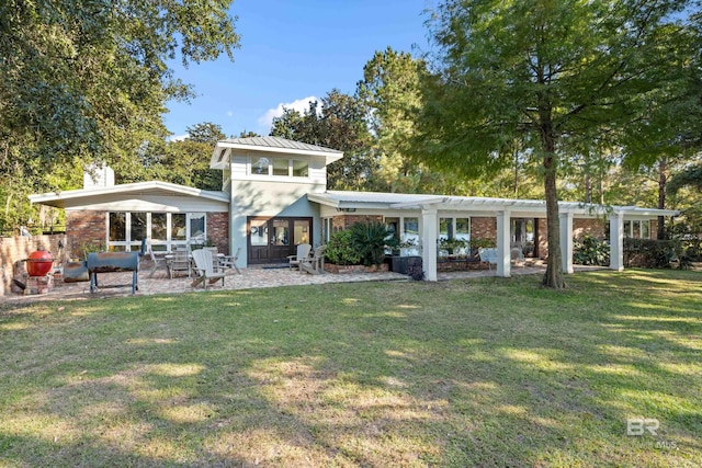 back of house with metal roof, a patio, a lawn, and a pergola