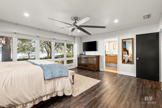 bedroom featuring visible vents, baseboards, dark wood finished floors, recessed lighting, and ensuite bathroom