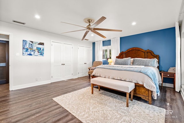 bedroom featuring visible vents, baseboards, multiple closets, recessed lighting, and wood finished floors