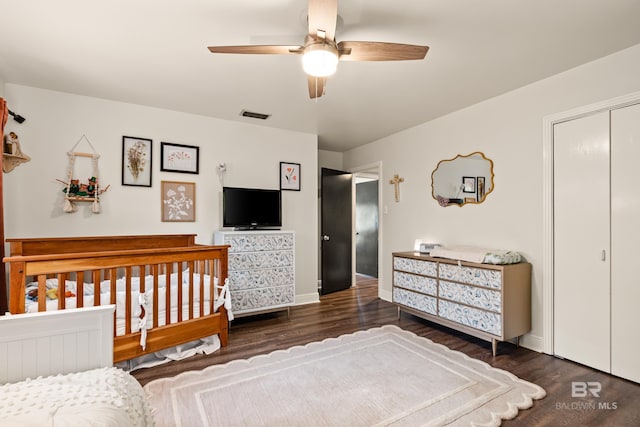 bedroom with a closet, visible vents, baseboards, and wood finished floors