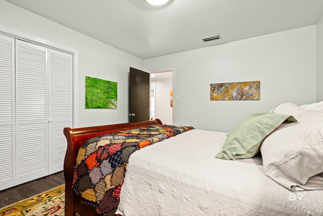 bedroom featuring a closet, visible vents, and wood finished floors