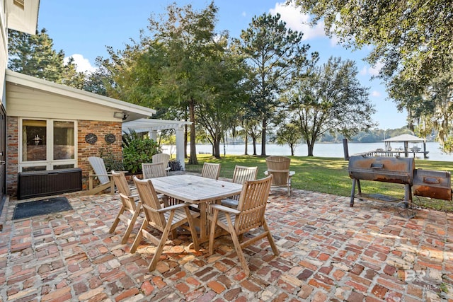 view of patio featuring a grill, outdoor dining area, and a water view