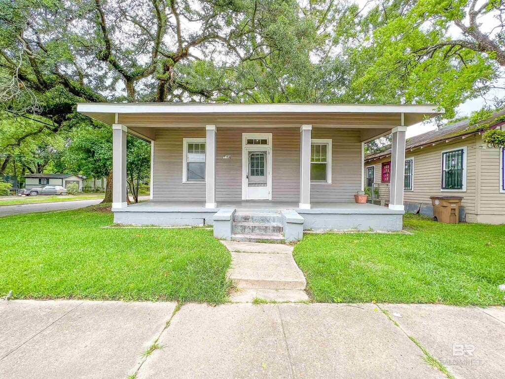 bungalow-style house featuring a porch and a front lawn