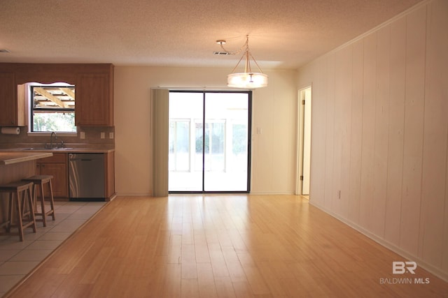 dining space featuring a textured ceiling, light hardwood / wood-style flooring, and sink