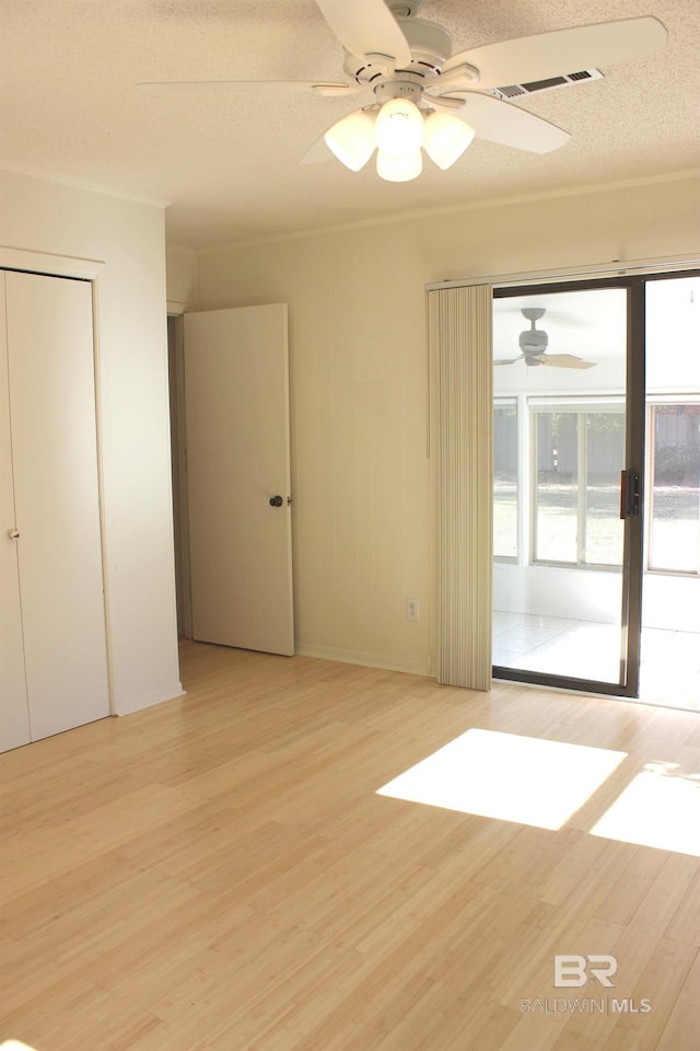 unfurnished room with ceiling fan, light hardwood / wood-style floors, and a textured ceiling