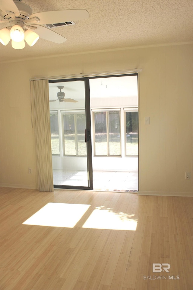 unfurnished room featuring a textured ceiling, light wood-type flooring, and ceiling fan