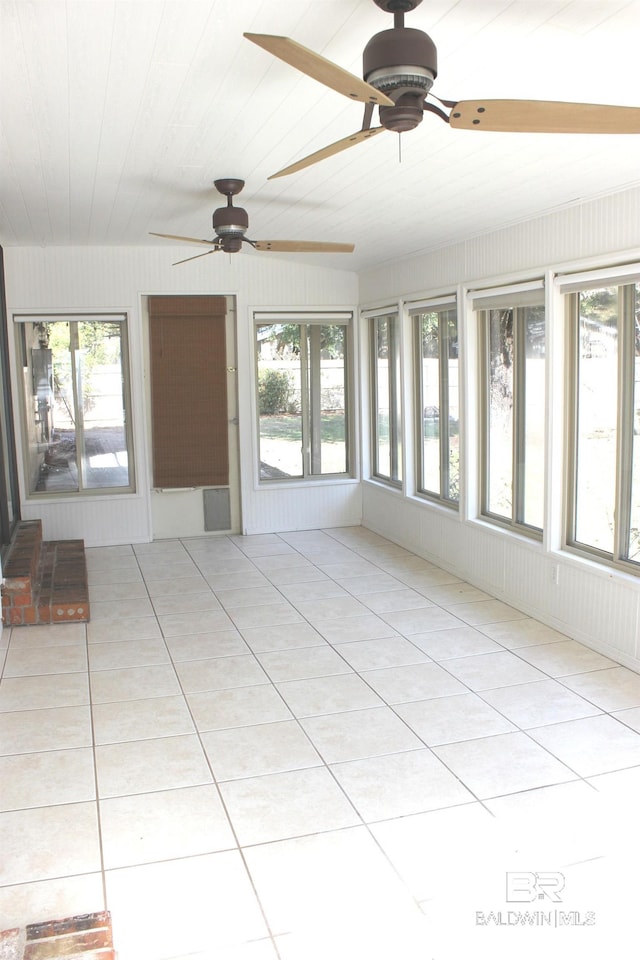 unfurnished sunroom featuring ceiling fan and plenty of natural light