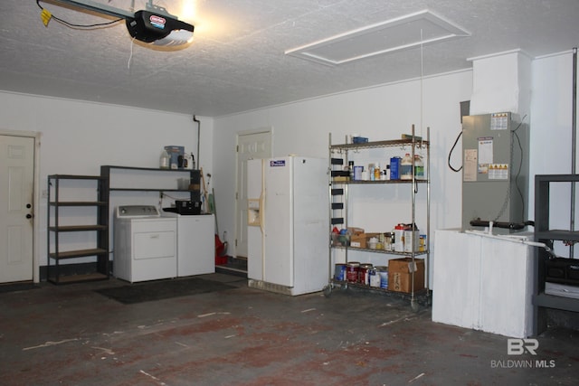 garage featuring white refrigerator, washing machine and dryer, and a garage door opener