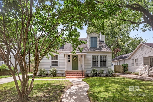 cape cod-style house featuring a front yard