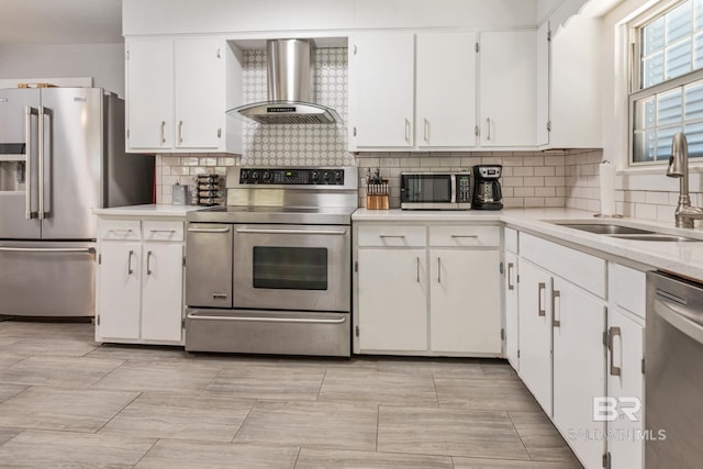 kitchen featuring white cabinetry, sink, wall chimney exhaust hood, stainless steel appliances, and tasteful backsplash