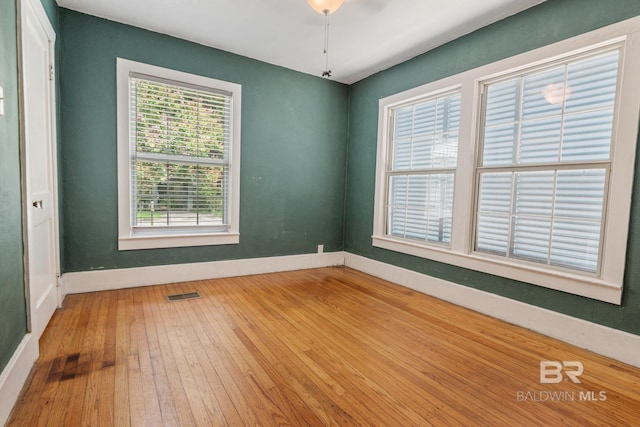 empty room with ceiling fan and wood-type flooring