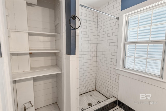 bathroom with tiled shower and a wealth of natural light