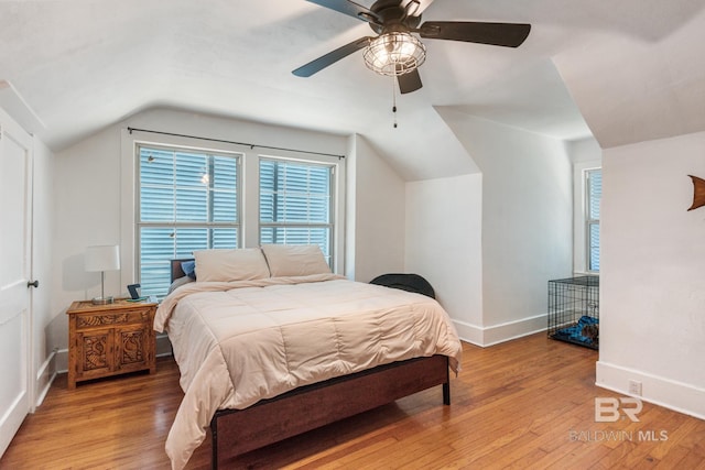 bedroom featuring multiple windows, ceiling fan, lofted ceiling, and light wood-type flooring