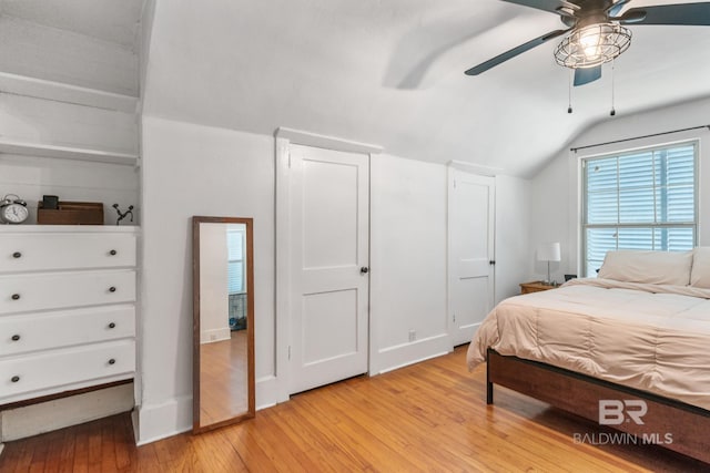 bedroom with ceiling fan, light hardwood / wood-style floors, and lofted ceiling