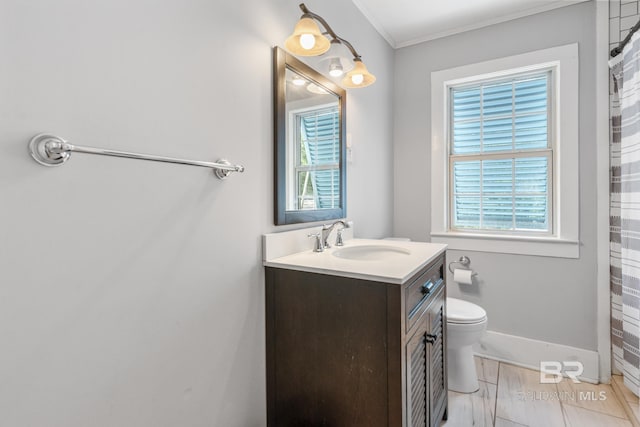 bathroom featuring vanity, toilet, a wealth of natural light, and ornamental molding