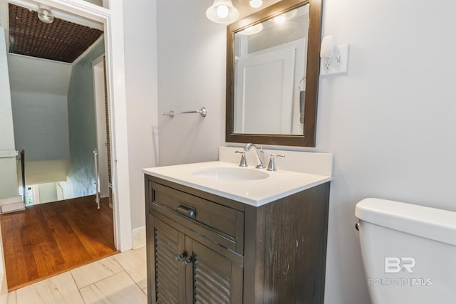 bathroom featuring hardwood / wood-style floors, vanity, and toilet