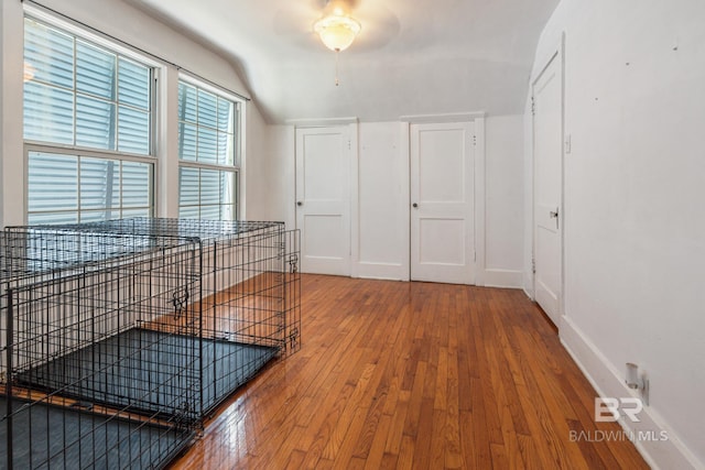 hallway featuring hardwood / wood-style floors and vaulted ceiling