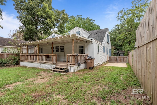 rear view of property featuring a yard and a deck